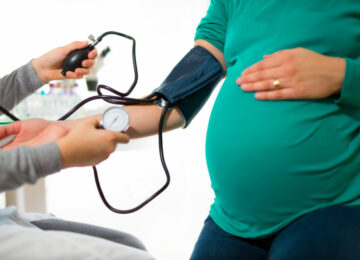 Pregnant woman at doctor's office having pressure measured, close up