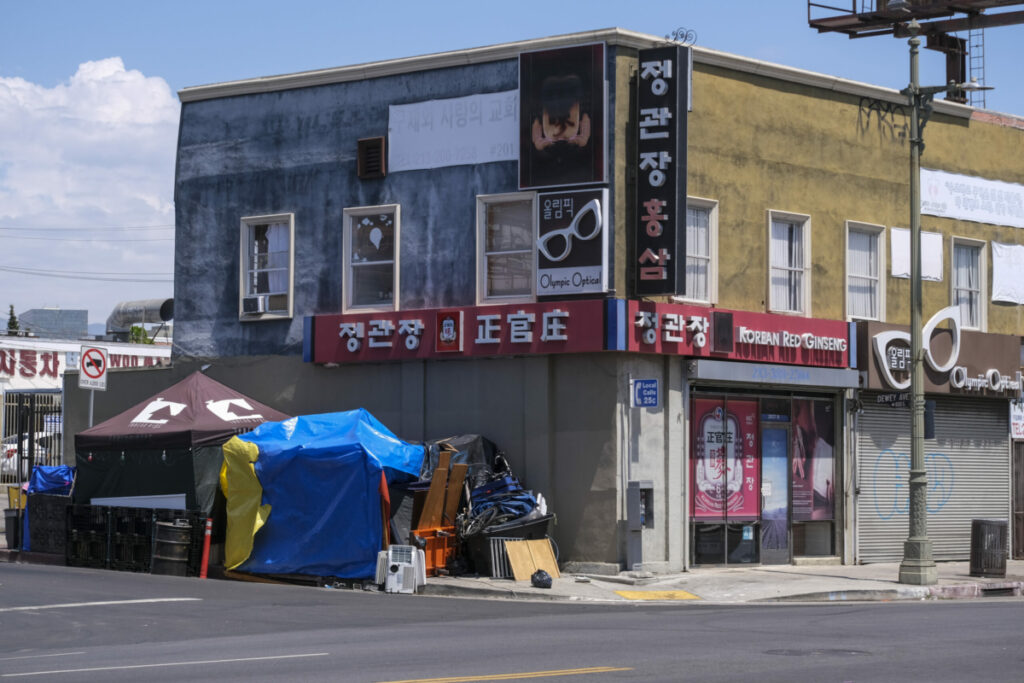 Homeless tents sit on the sidewalk next to a business near Olympic Blvd and Dewey Ave. in Los Angeles, Aug. 16, 2022. (Photo by Ringo Chiu)