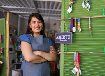 Woman small shop owner with "open" sign concept of opening or opening small businesses